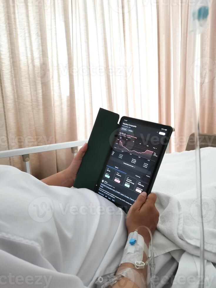 Patients monitor the Nasdaq composite index via tablets in their hospital beds. Planning investments take profit, trade stock exchange market and cryptocurrency data, financial. photo