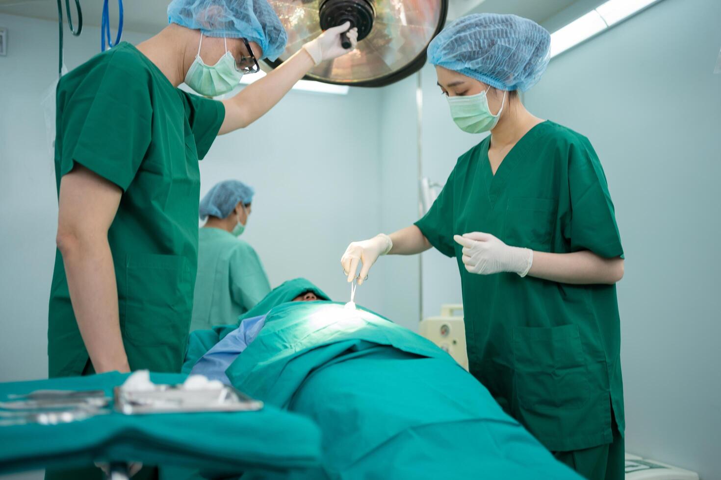 Asian Professional surgeons team performing surgery in the operating room, surgeon, Assistants, and Nurses Performing Surgery on a Patient, health care cancer and disease treatment. photo