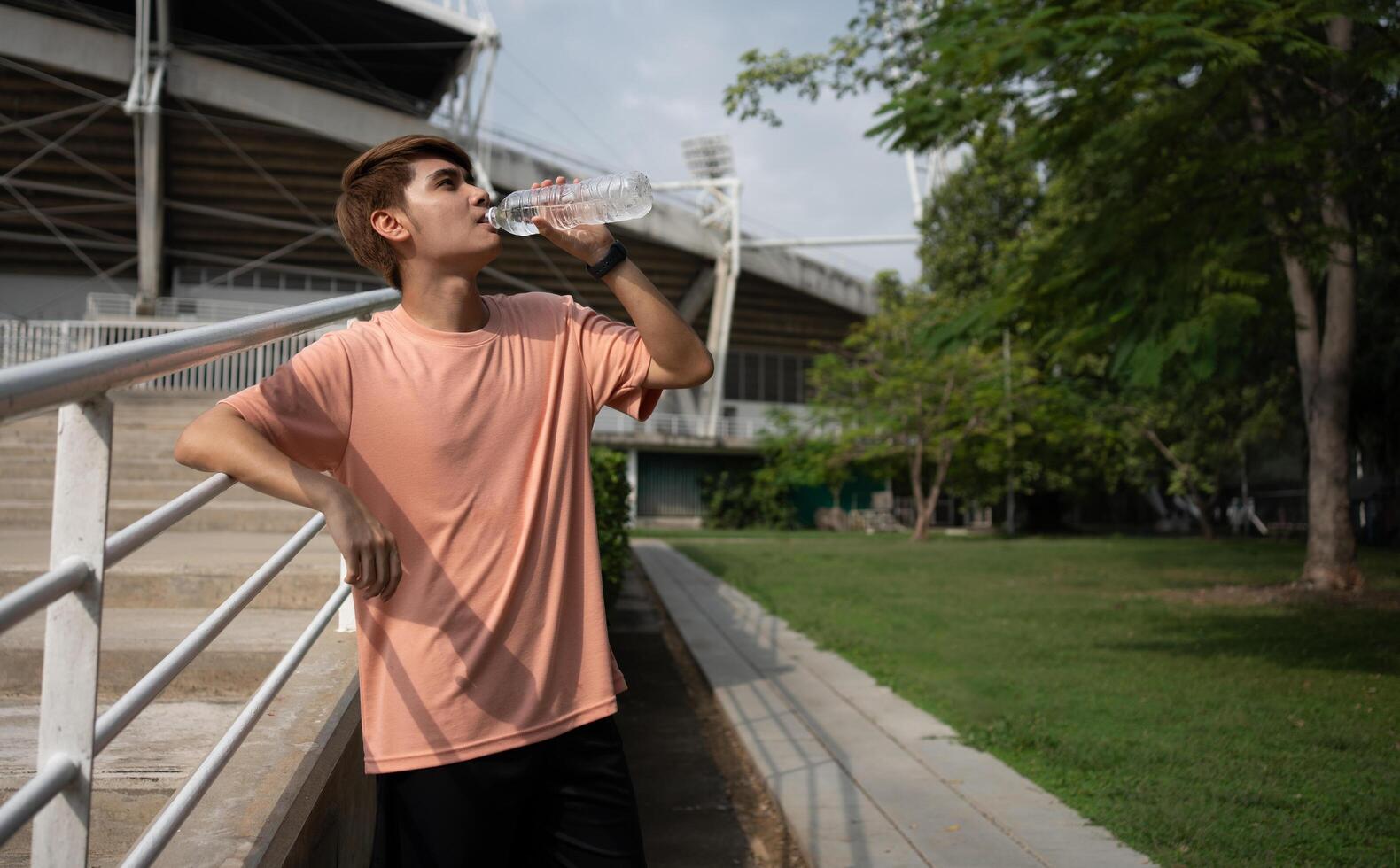 Happy healthy men drinking water from bottle after workout exercise. Sports, nutrition bottle, and men athletes drink liquid for hydration after exercising, a Healthy and active lifestyle concept photo