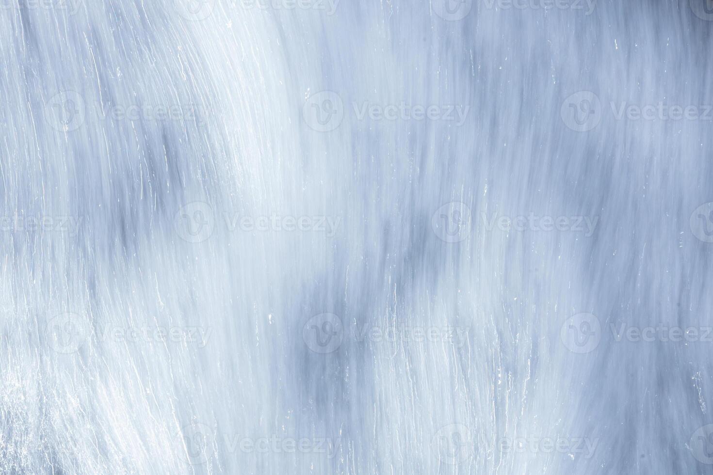 Water flowing over smooth stones creates a tranquil, natural texture in the background photo