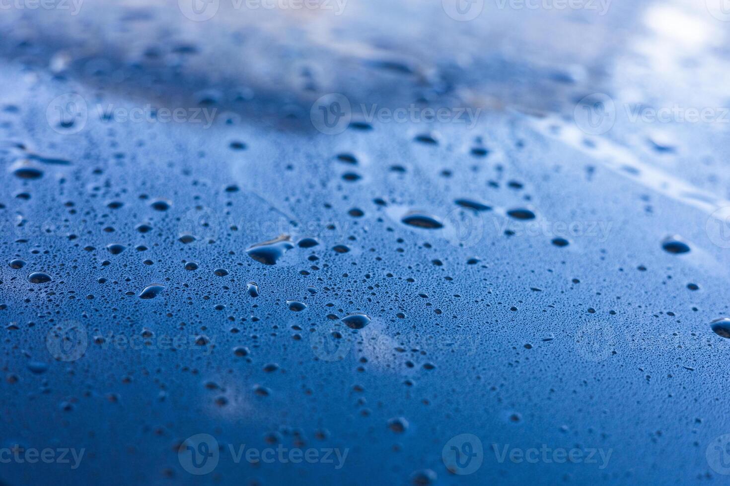 Water droplets accumulate on a blue surface after rainfall during early morning hours photo