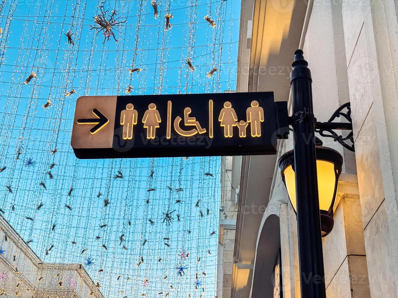 A Directional sign indicating restrooms and accessibility features in public space photo