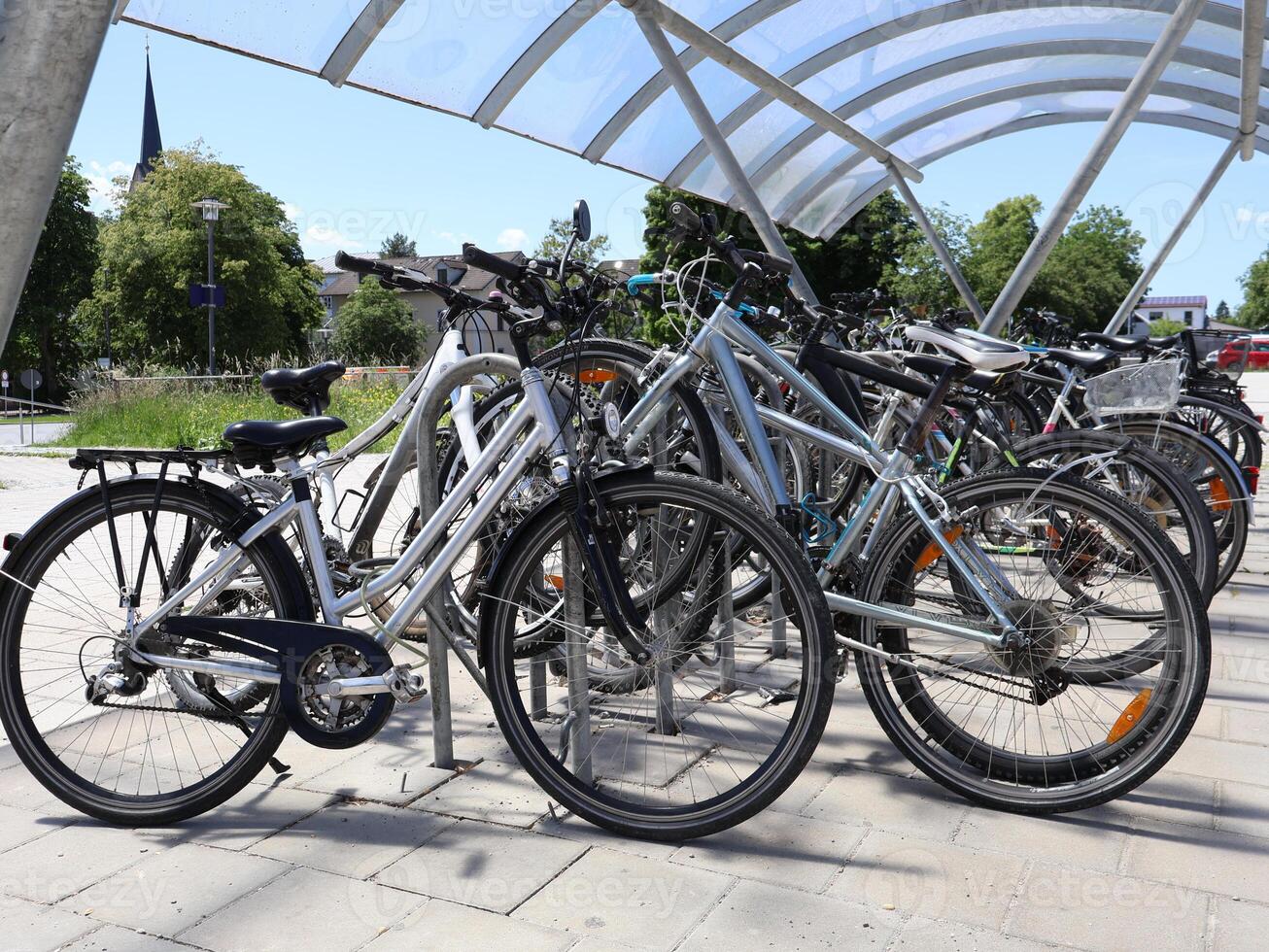 Group of Bicycles Parked Under a Modern Canopy on a Sunny Day photo