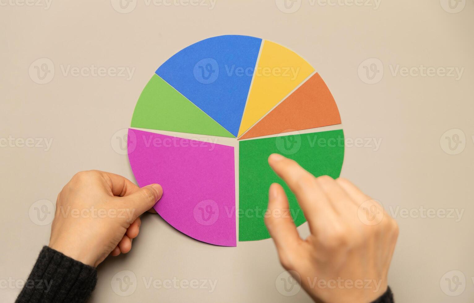 Hand selecting a segment on a colorful pie chart representing data analysis, investment portfolio allocation, and strategic financial planning photo