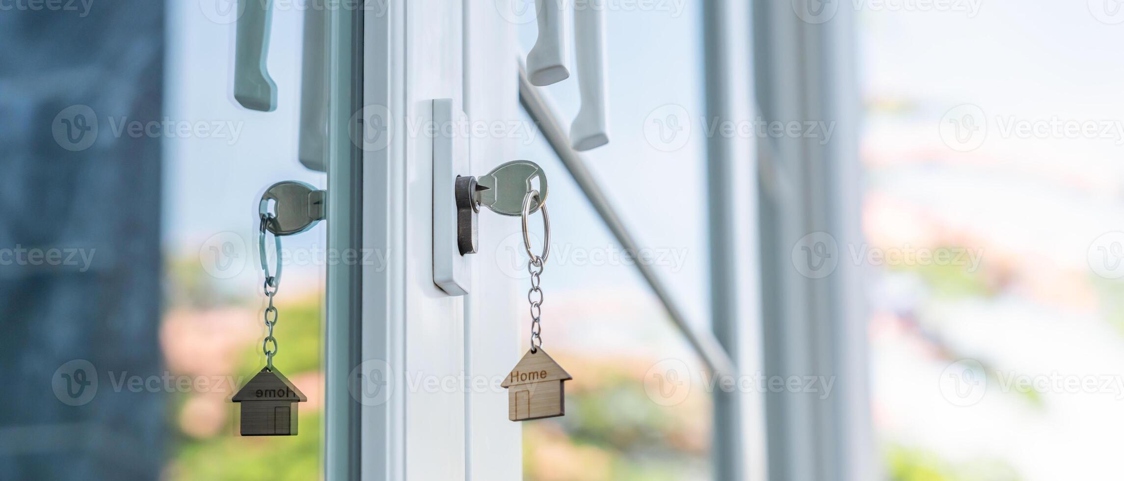 key in unlocking house is plugged into the door. Second hand house for rent and sale. keychain is blowing in the wind. mortgage for new home, buy, sell, renovate, investment, owner, estate photo
