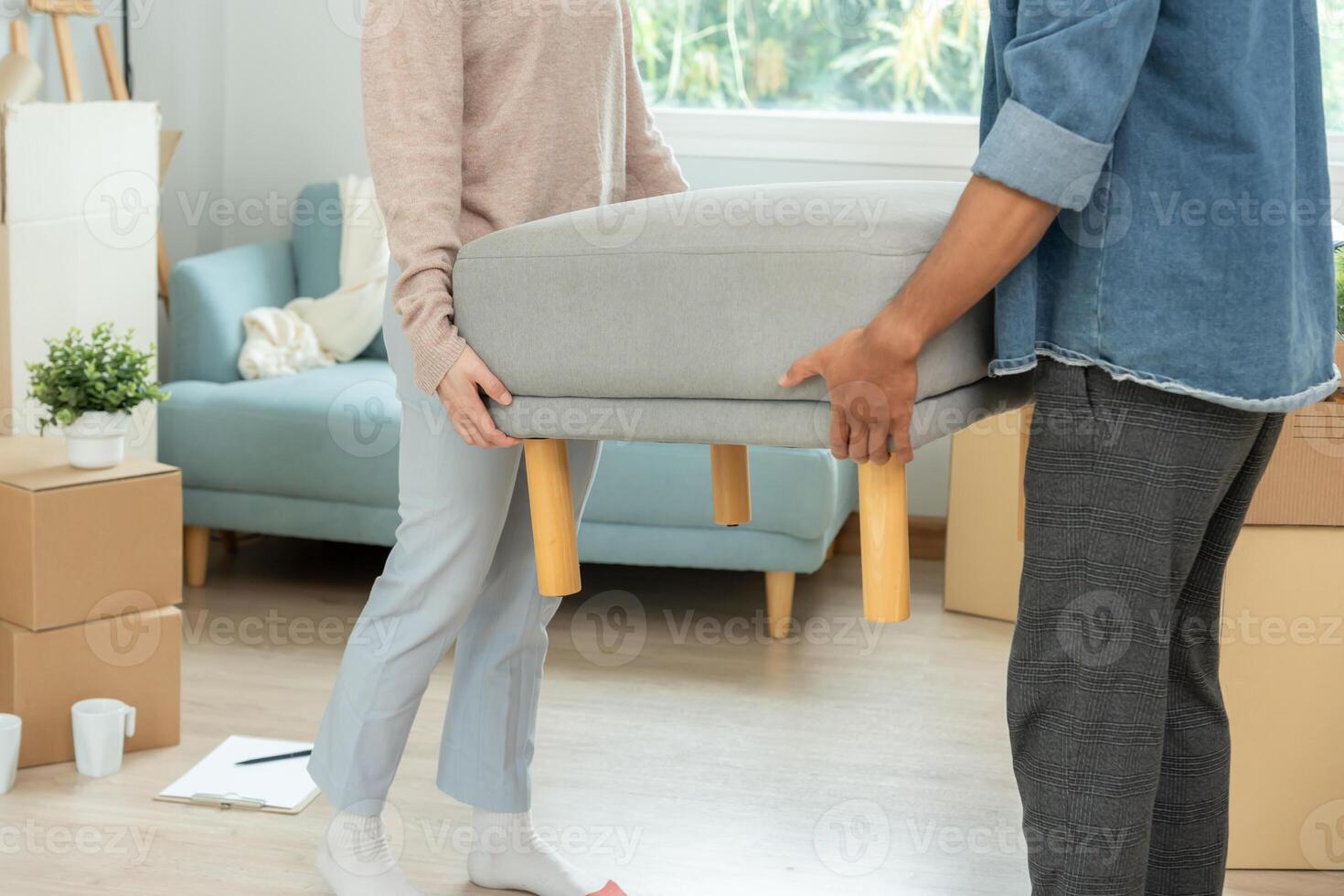 Moving house, relocation. Couple help set sofa and move furniture for new apartment, inside the room was a cardboard box contain personal belongings. move in the new condominium photo