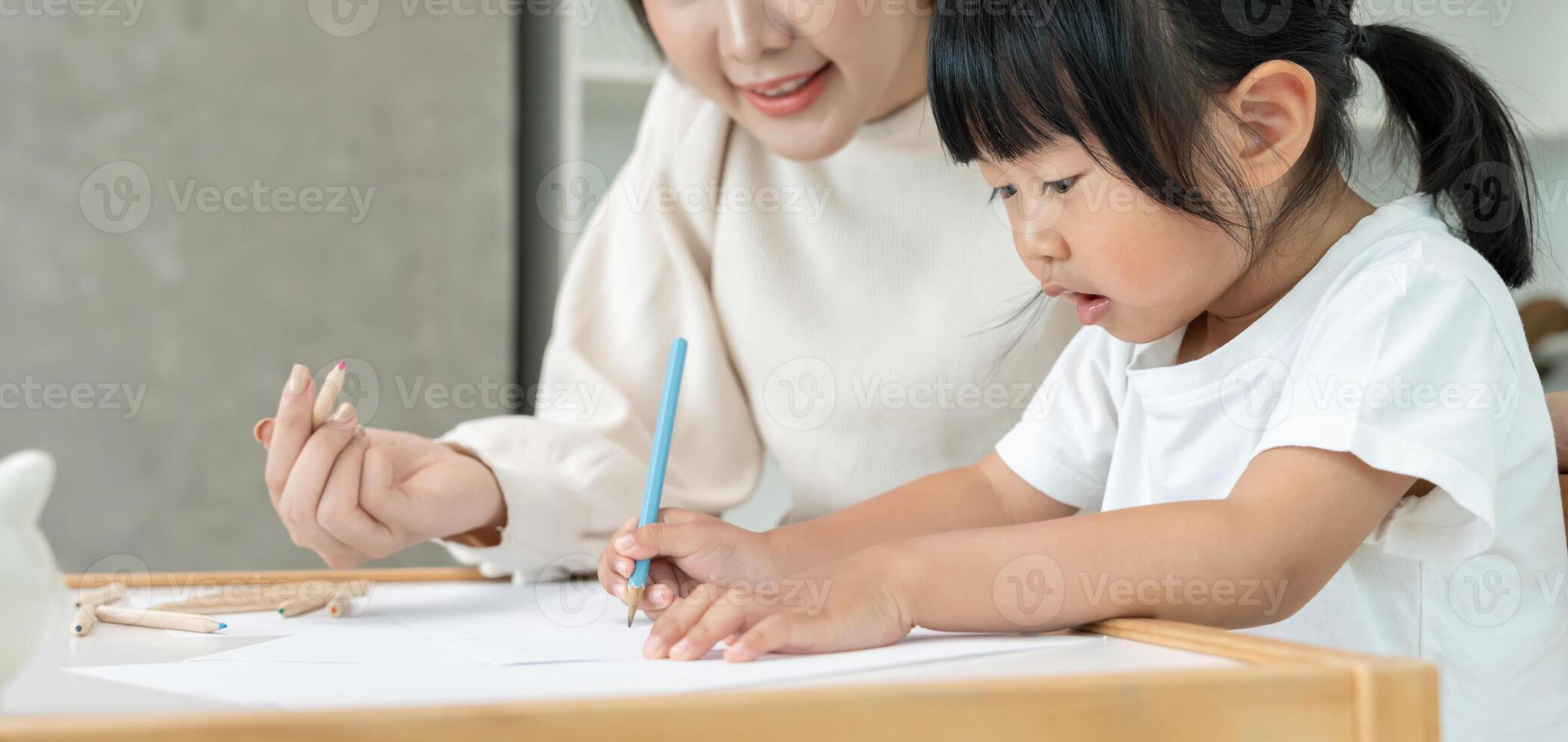Happy Asia mother playing learning paint for little girl. Funny family is happy and excited in the house. Mother and daughter having fun spending time photo