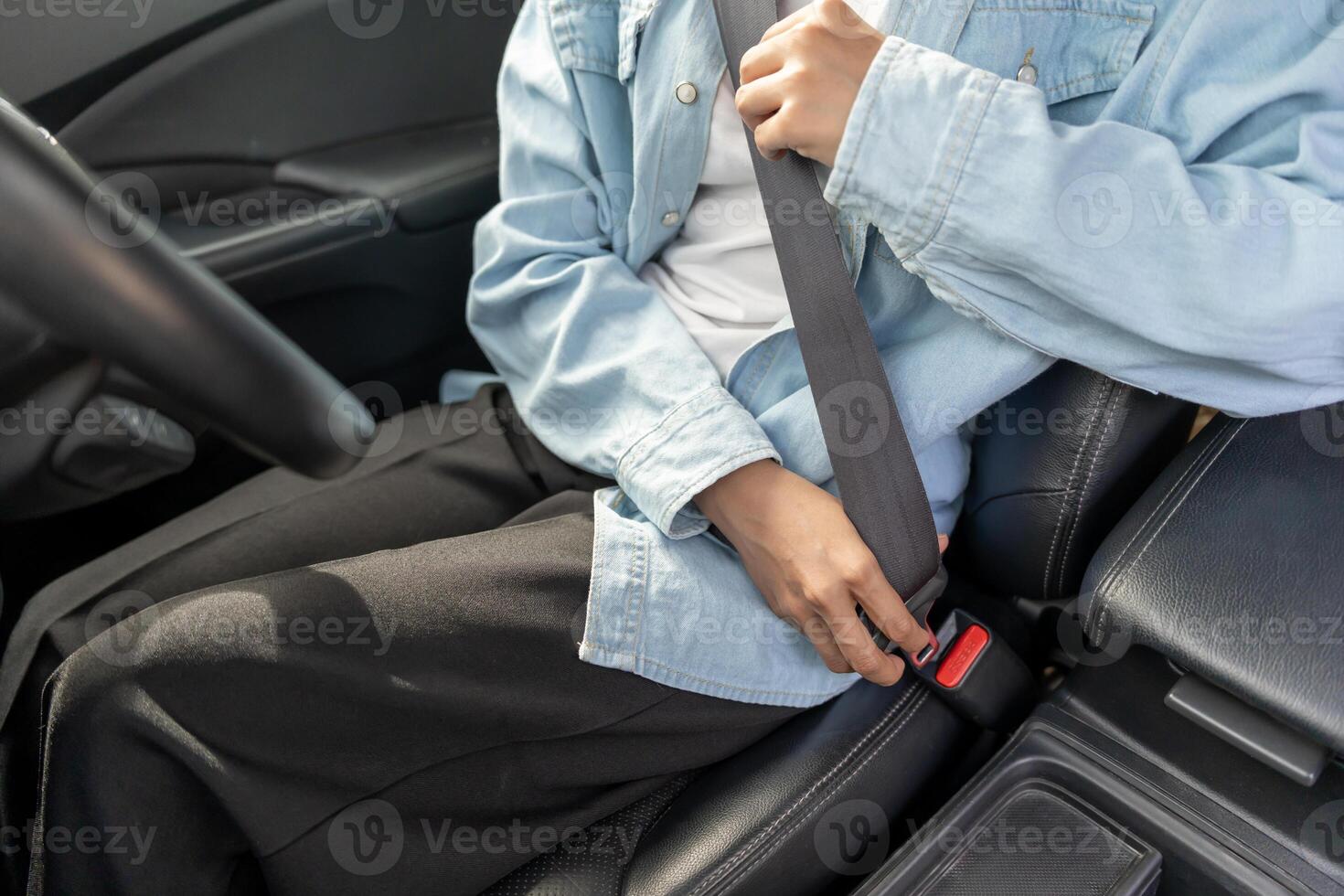 Woman use seatbelt and drives with intent, safe driving, driving practice, cheerful woman sits comfortably in the driver's seat with her hand confidently photo