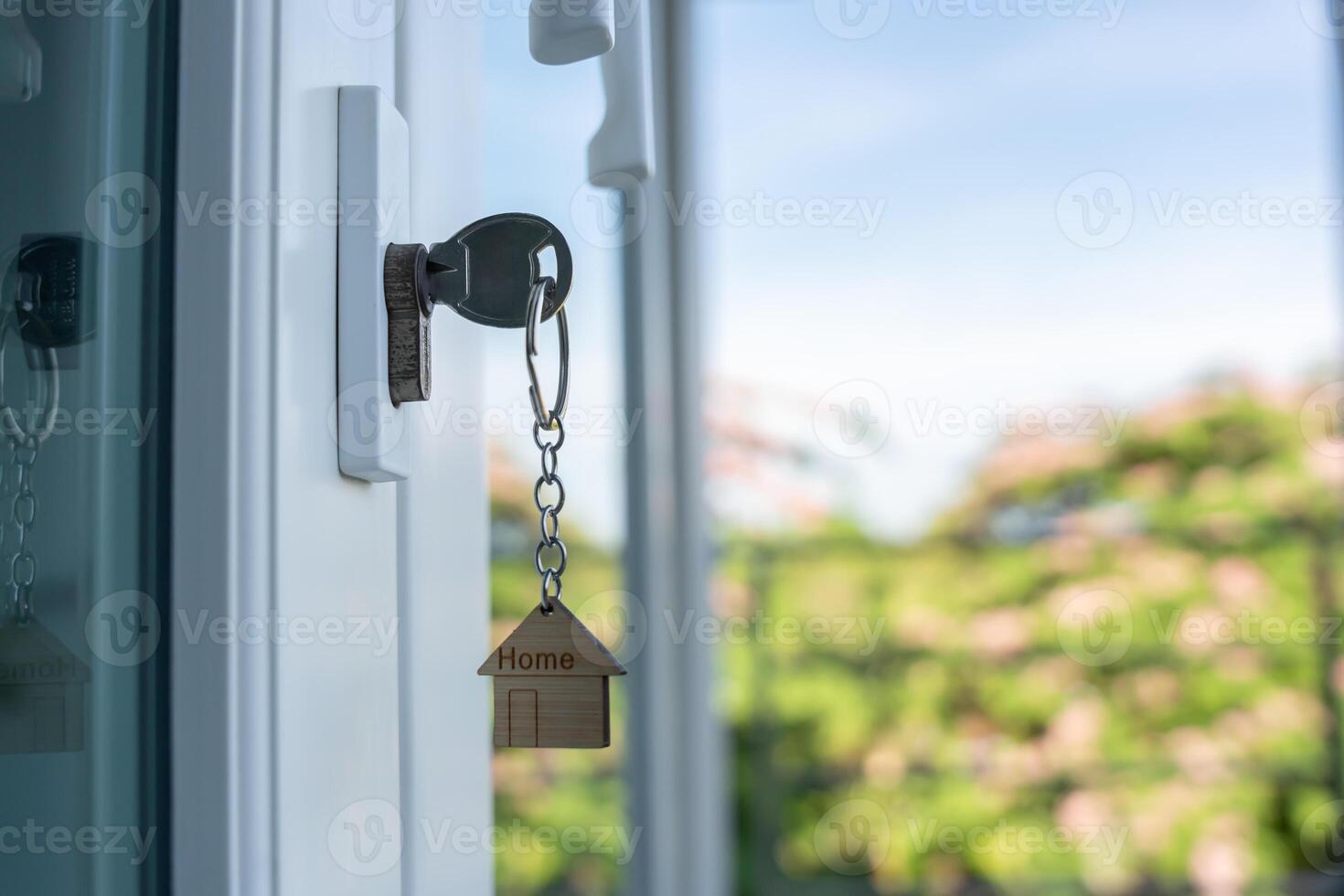 Landlord key for unlocking house is plugged into the door. Second hand house for rent and sale, keychain is blowing in the wind. mortgage for new home, buy, sell, renovate, investment, owner, estate photo