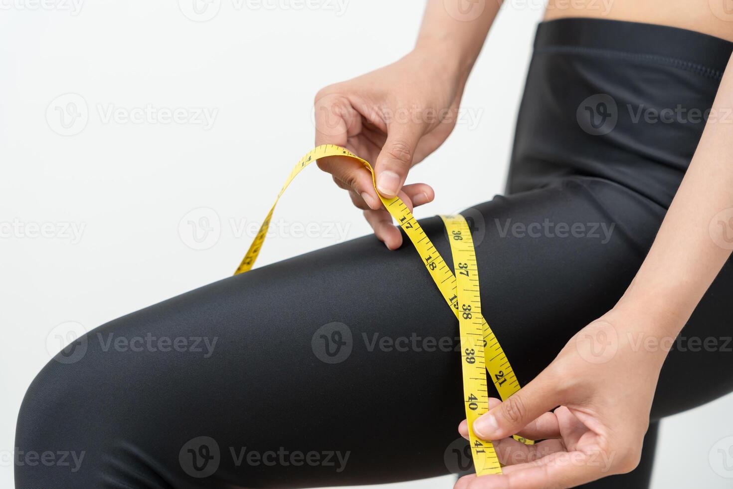 dieting. Beauty slim female use tape measure of thigh. Woman in exercise clothes achieves weight loss goal for healthy life, crazy about thinness, thin waist, nutritionist. photo