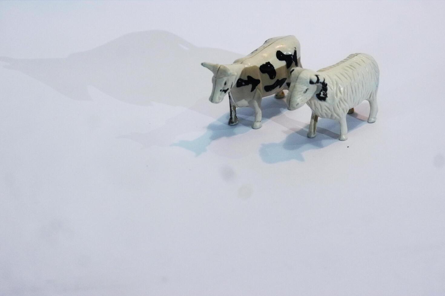 Two toy cows standing next to each other photo