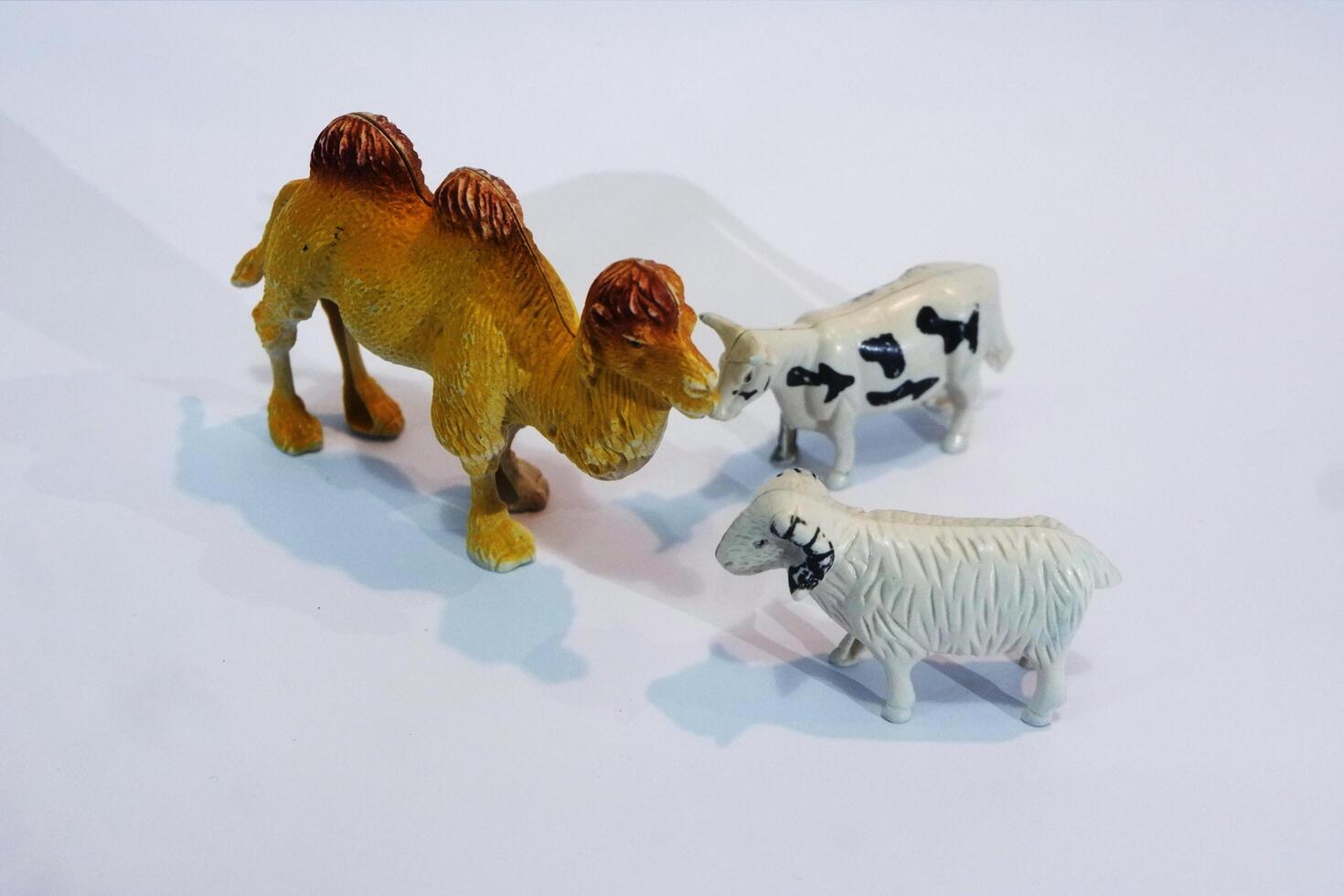 Three toy animals are shown on a white surface photo