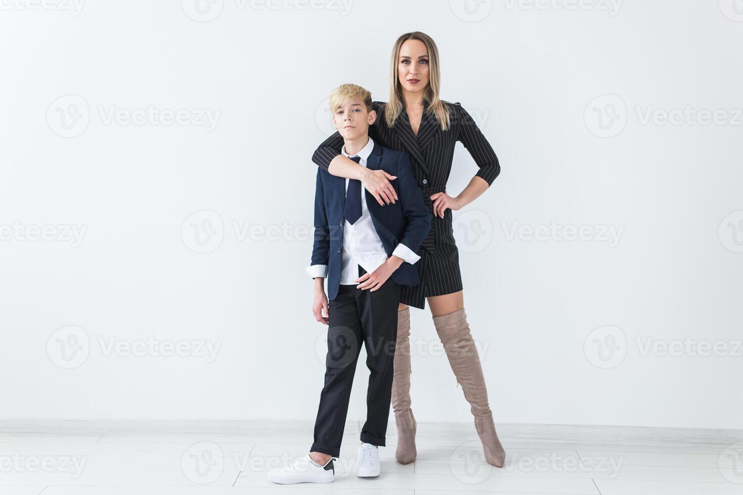Teenager and single parent - Young mother and son standing together on white background with copy space. photo