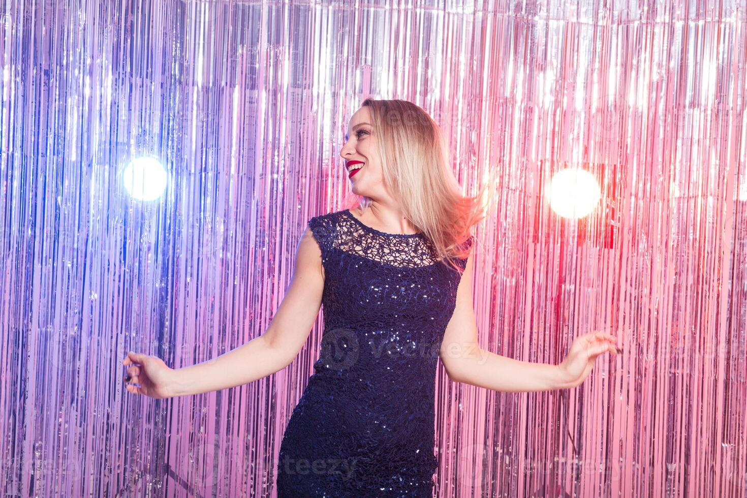 blonde woman dancing at night disco club. Party, holidays and celebration concept. photo