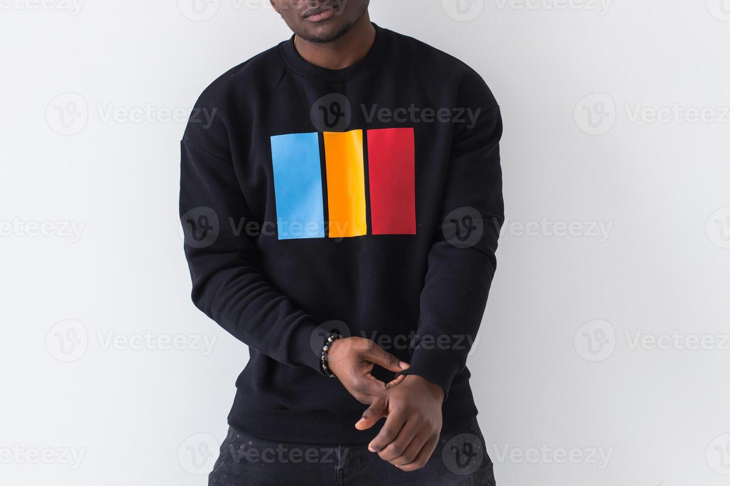 Handsome African American man posing in black sweatshirt on a white background, close-up. Youth street fashion photo with afro hairstyle.