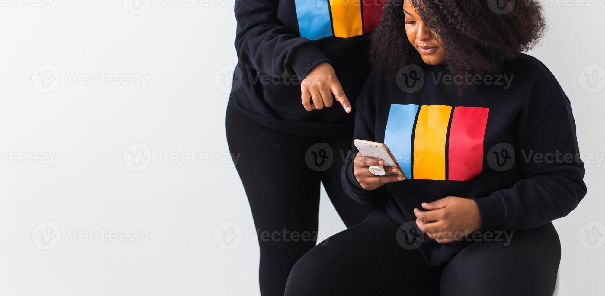 African american woman holds smartphone on white background with copy space photo