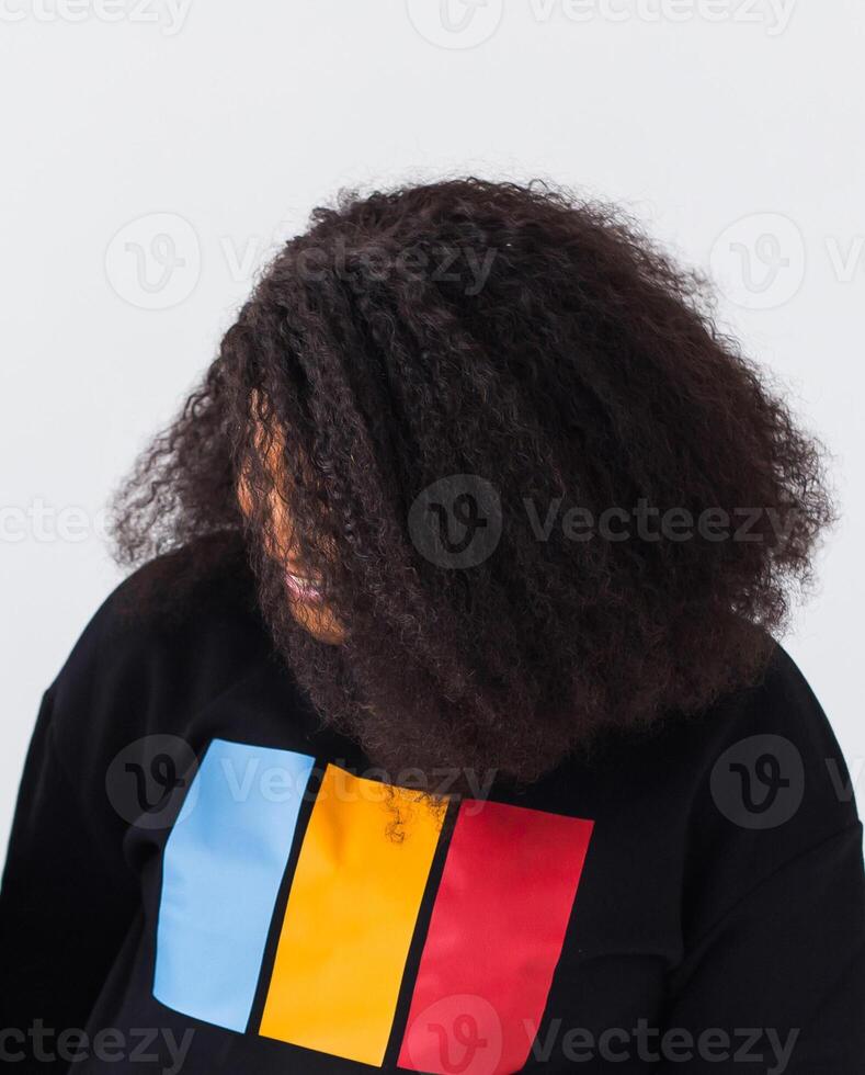 Young beautiful african american girl with an afro hairstyle. Portrait on white background. Girl looking aside. photo