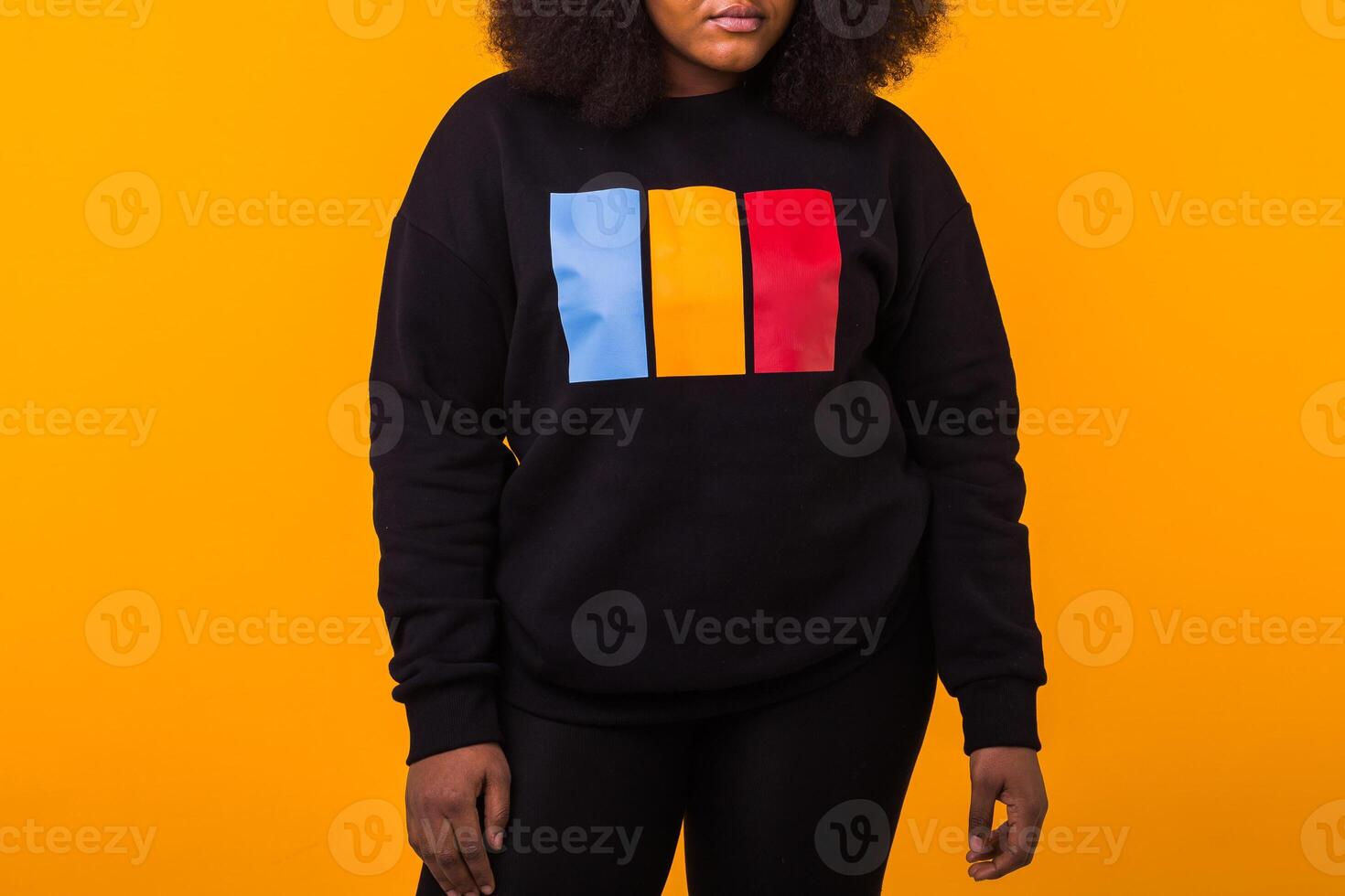 Close-up of african american girl with an afro hairstyle. Portrait on yellow background. Street fashion. photo