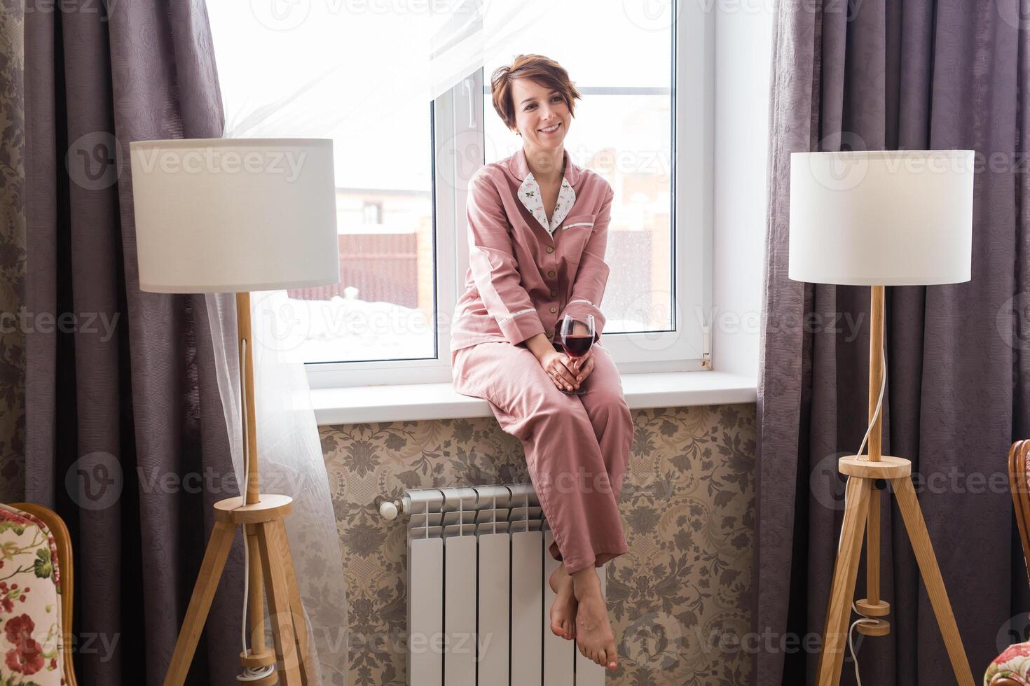 Young brunette woman relaxing with red wine at home. photo
