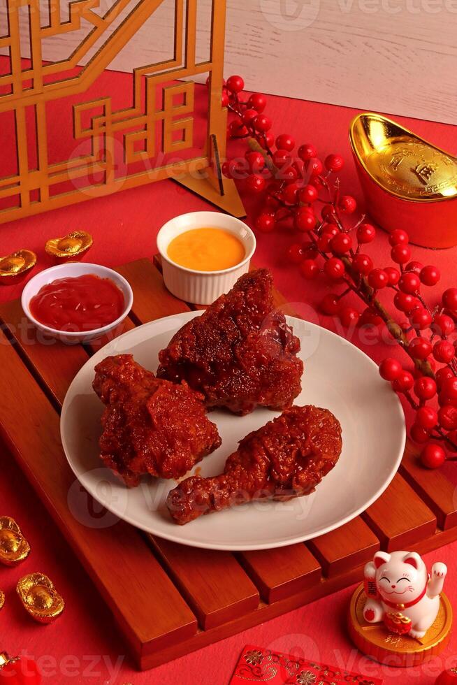 a plate of fried chicken on a table with red decorations photo