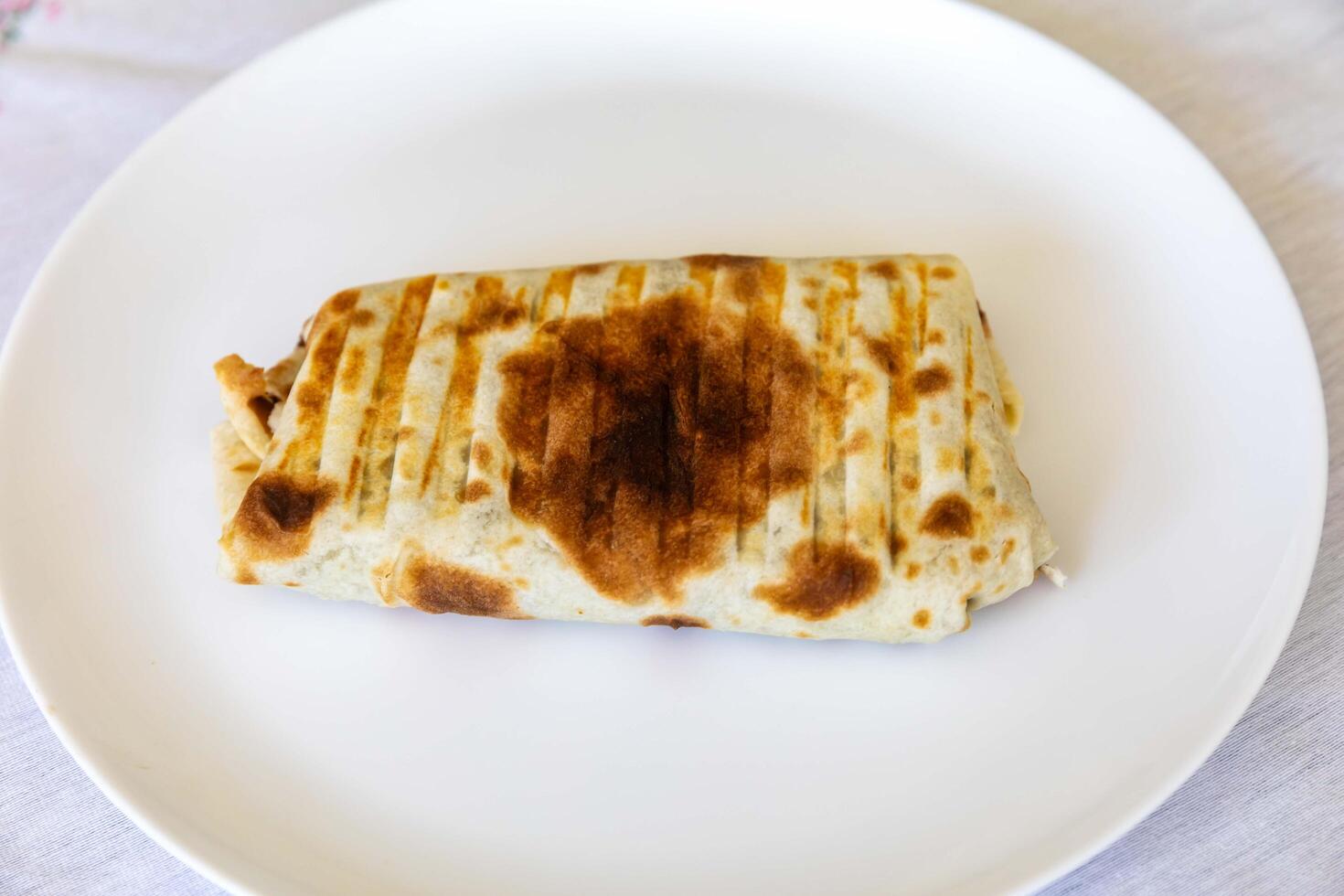 Close-up of a delicious shawarma wrap held in hand portrait photo