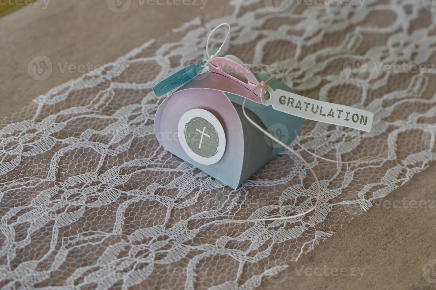 Lovingly wrapped small gift package for confirmation with ribbon and a lettering GRATULATION means congratulation photo