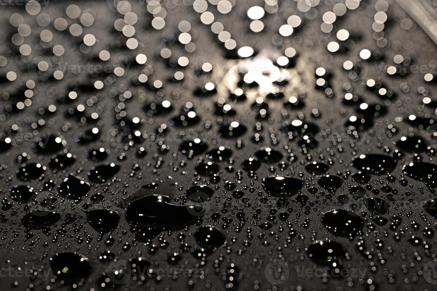 A close Up of many Water Droplets on Dark Surface photo