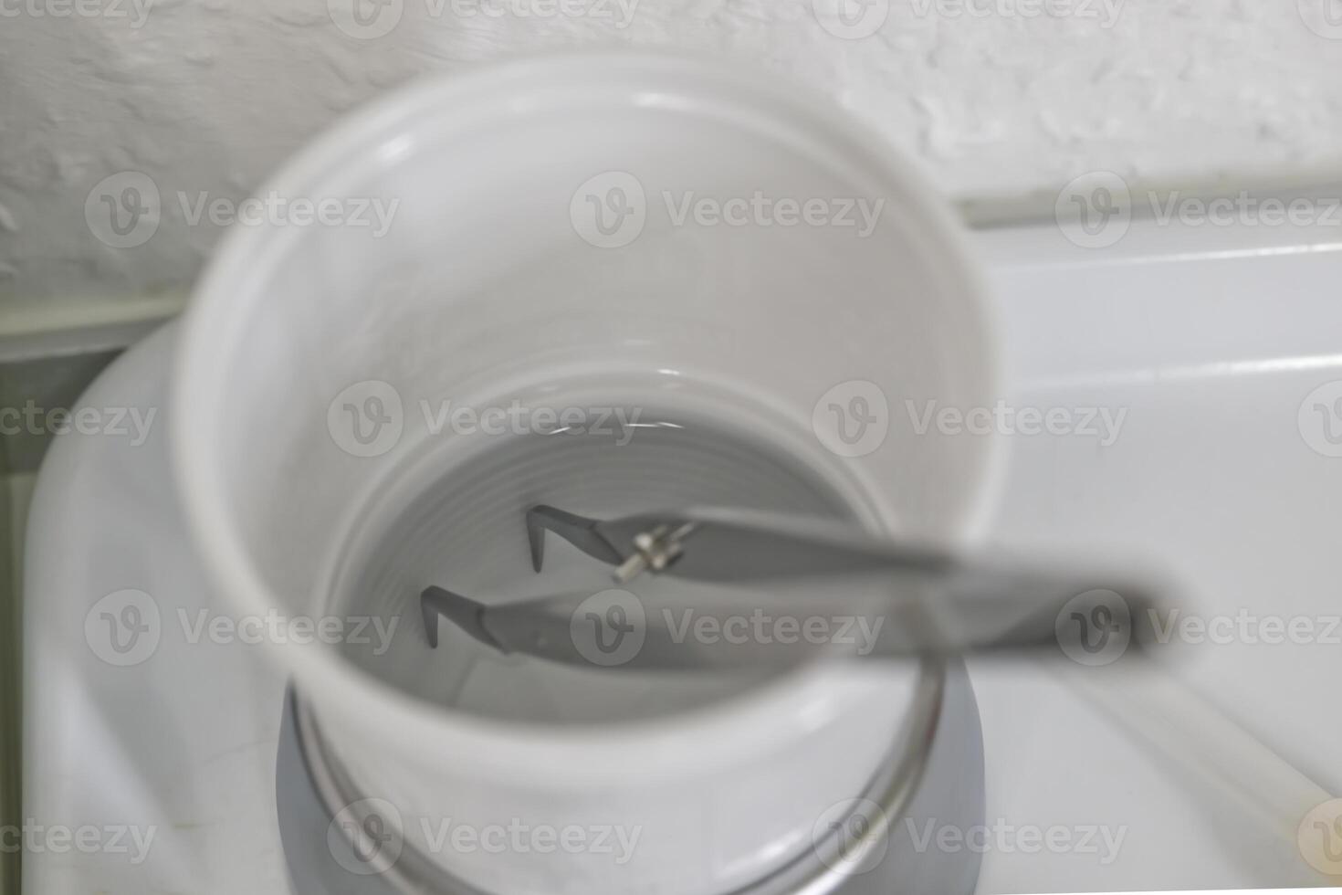 Tweezers in a Cup of Water photo