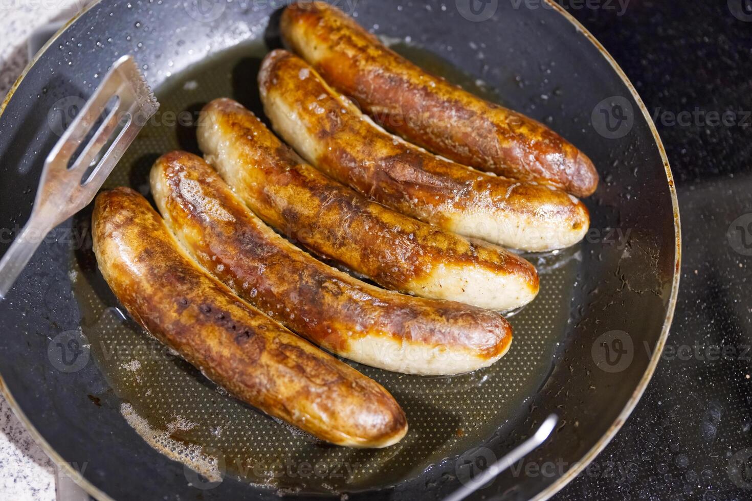 Golden-Brown Sausages Sizzling in a Frying Pan photo