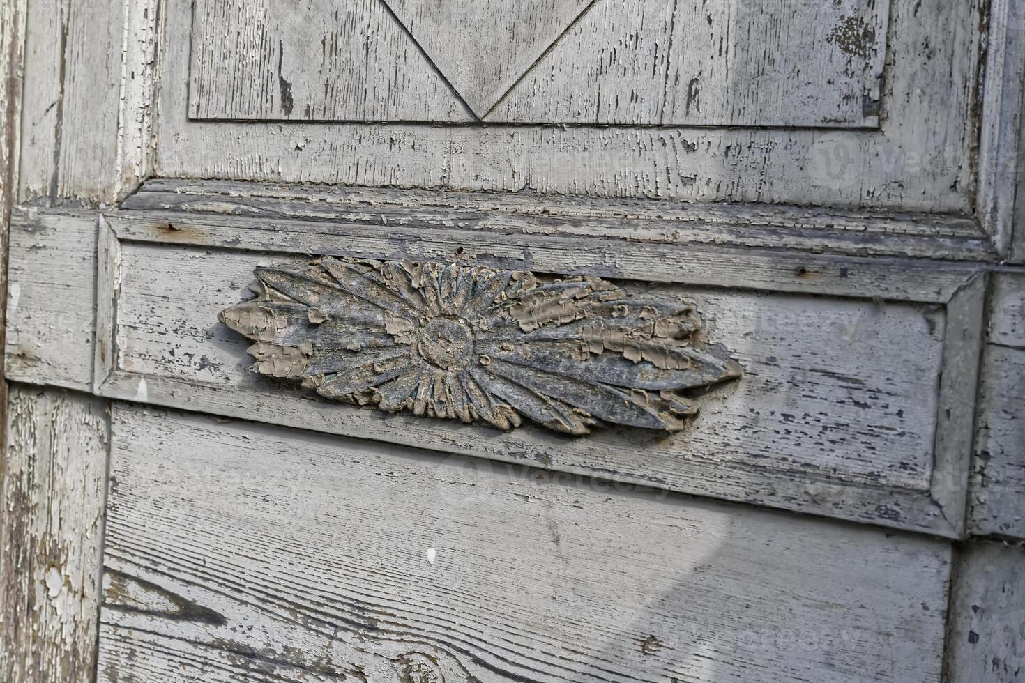 Ornate Weathered Wooden Door with Floral Carving photo