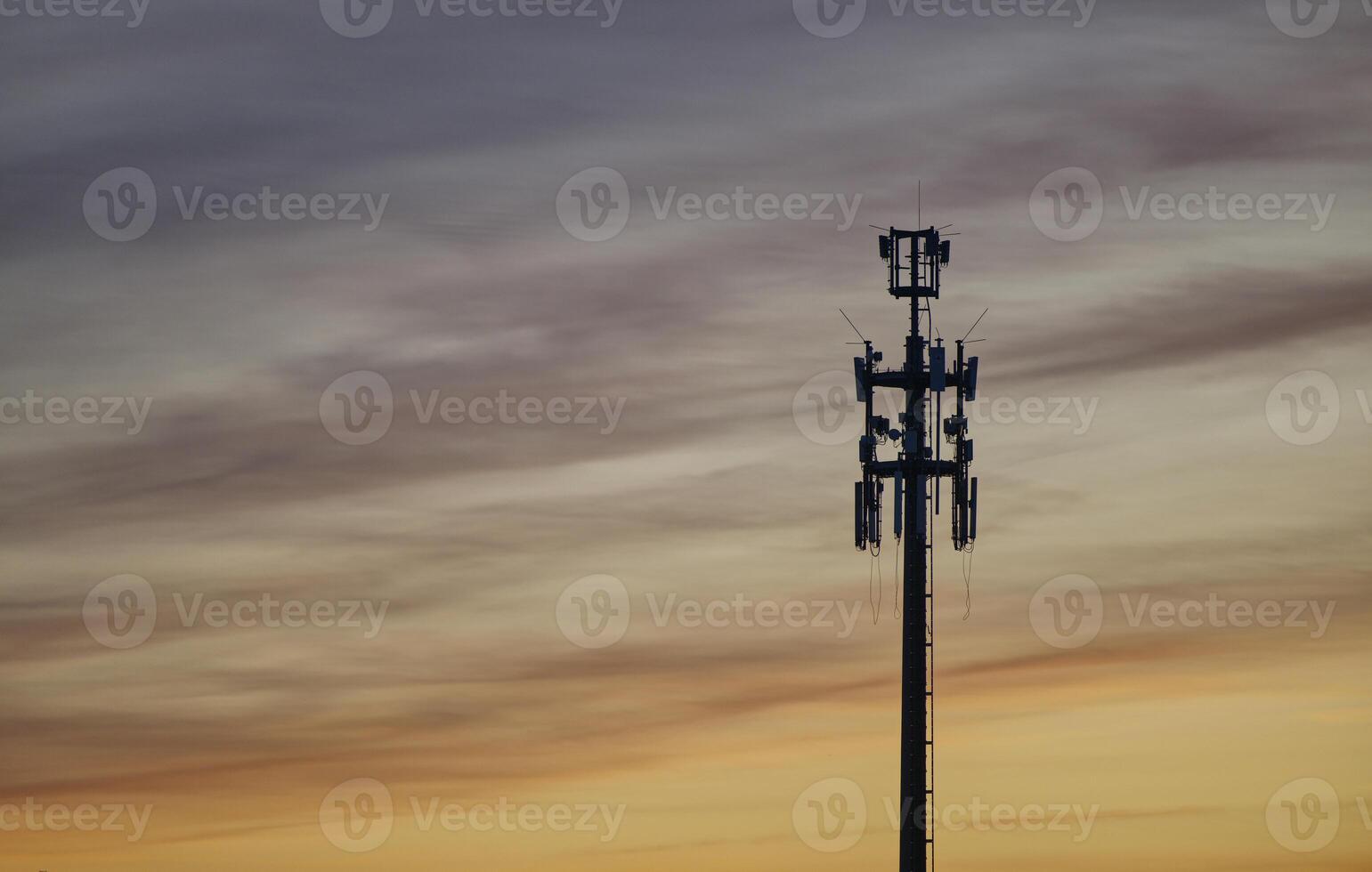 A radio tower for LTE UMTS and mobile internet in Hamburg at sunset against a golden backdrop photo