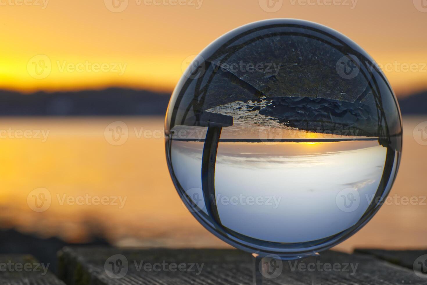 A glass ball is reflecting early summer sunset in Solituede near Flensburg in beautiful golden colors photo