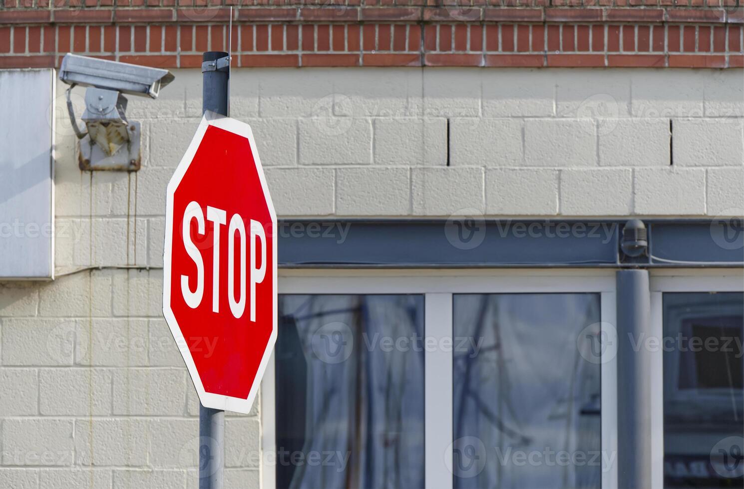 In Flensburg Harbor a surveillance camera is mounted on a building, in front of which is a STOP sign photo