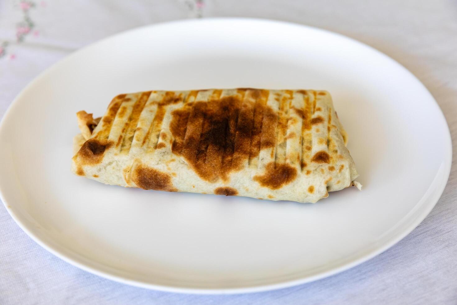 Close-up of a delicious shawarma wrap held in hand top view photo
