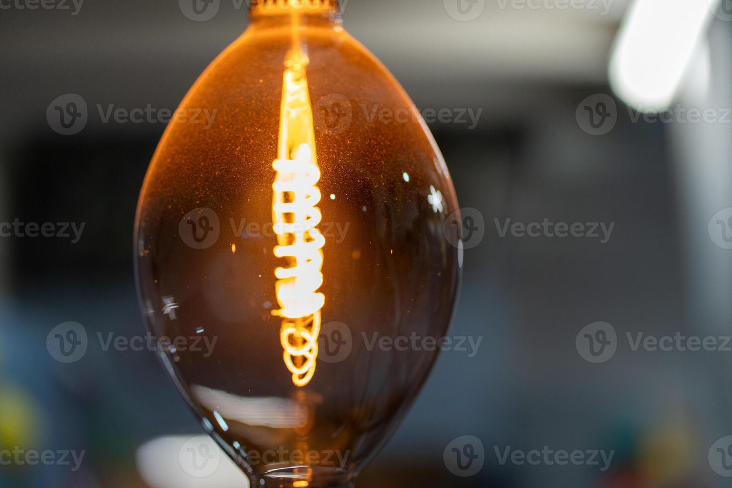 Decorative antique style filament light bulb glowing softly photo