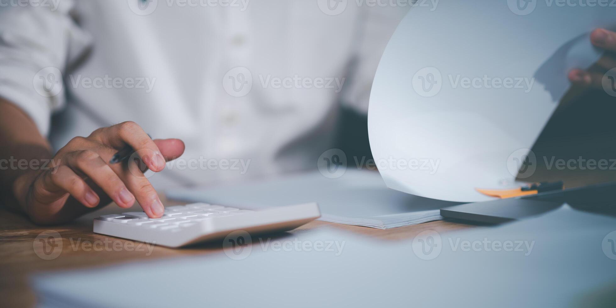 Planning to assess and review budgets,concept of finance and investment ,Businessman calculating figures in company financial documents with a calculator ,analysis of company financial data photo