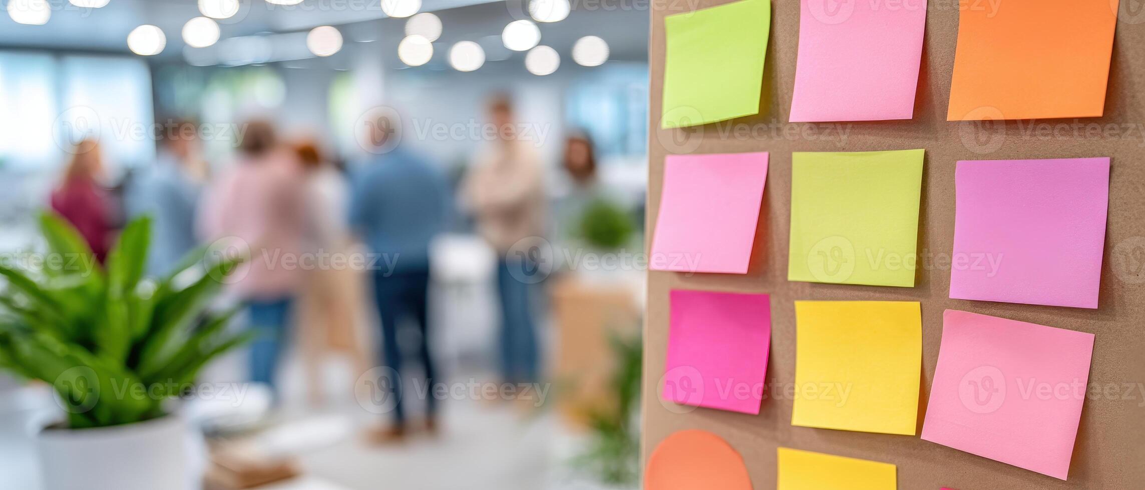 Inclusive workplace culture is shown with colorful sticky notes on board and blurred people collaborating in bright modern office space photo
