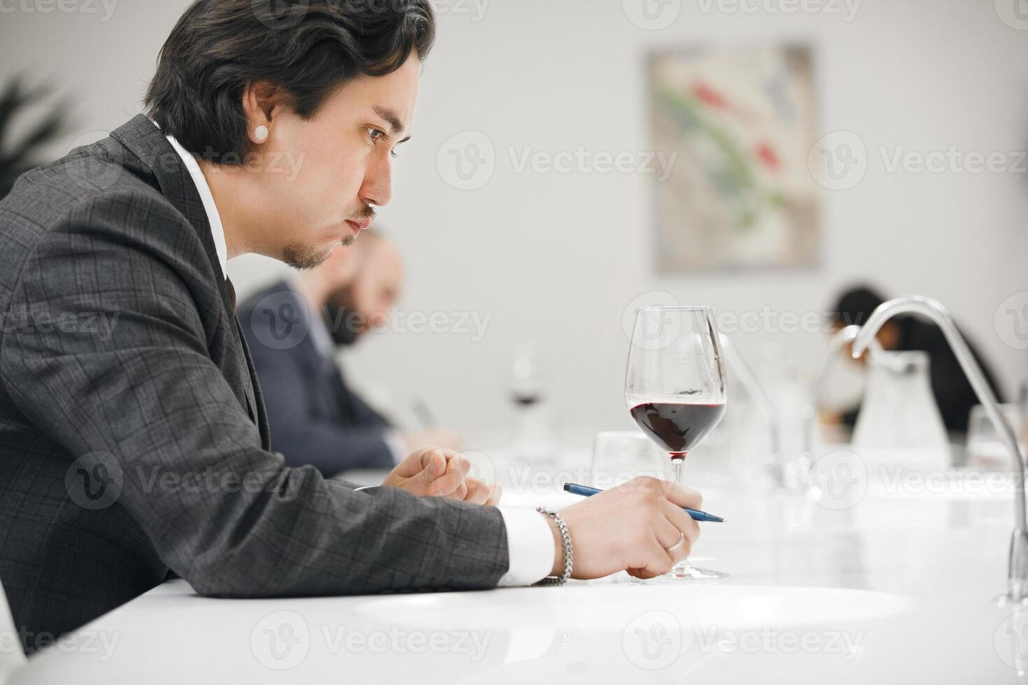 Professional Sommelier Assessing Wine Quality by Means Smell, Taste and it Color. photo