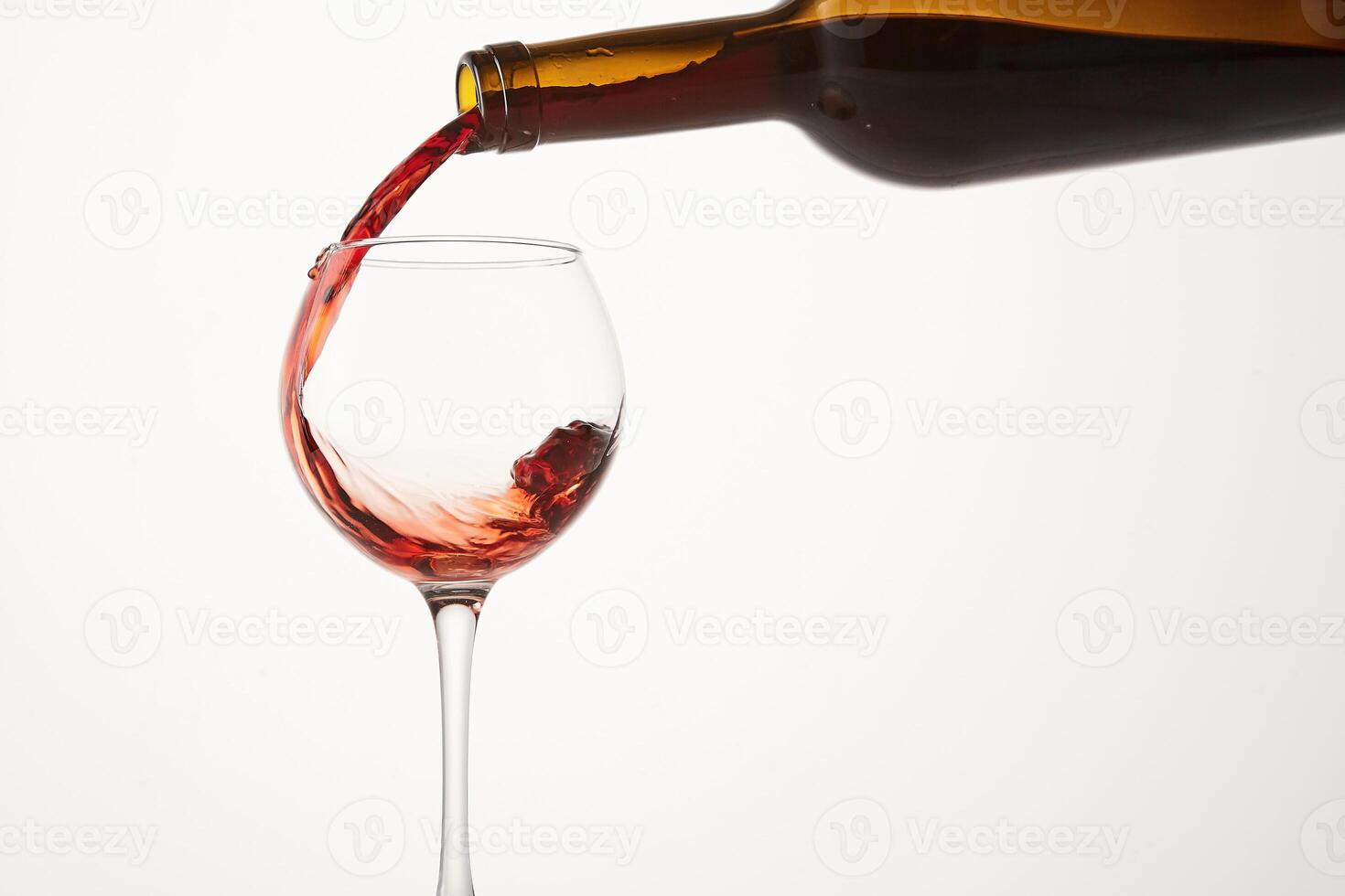 Round wave of pink wine flowing from bottleneck to glass. photo