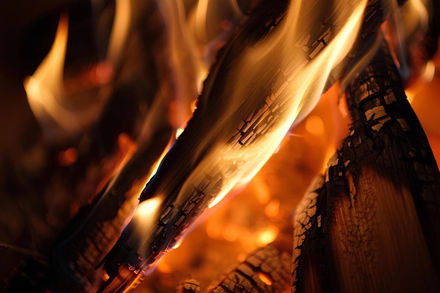 Close-up view of burning charred logs, firewood with orange-yellow tongues of flame. Smoldering embers glow from within the wood photo