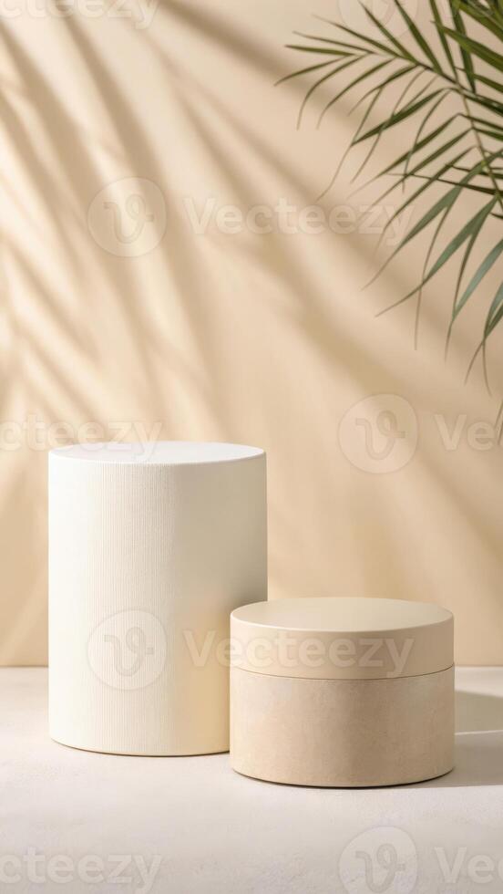 Beige cylindrical display stands with palm leaf shadows photo