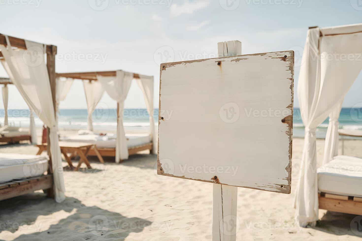 Weathered white sign post with beach cabanas and ocean background photo