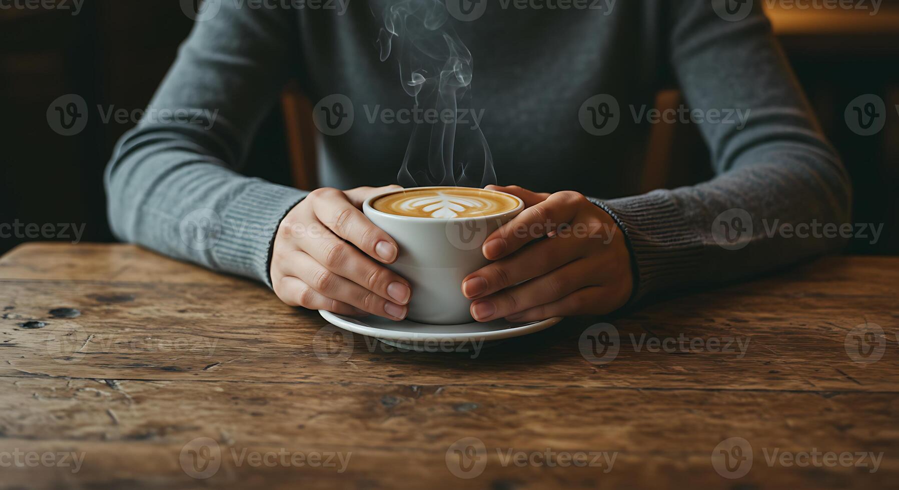 Holding Cup of Coffee Latte on Rustic Wood Table photo