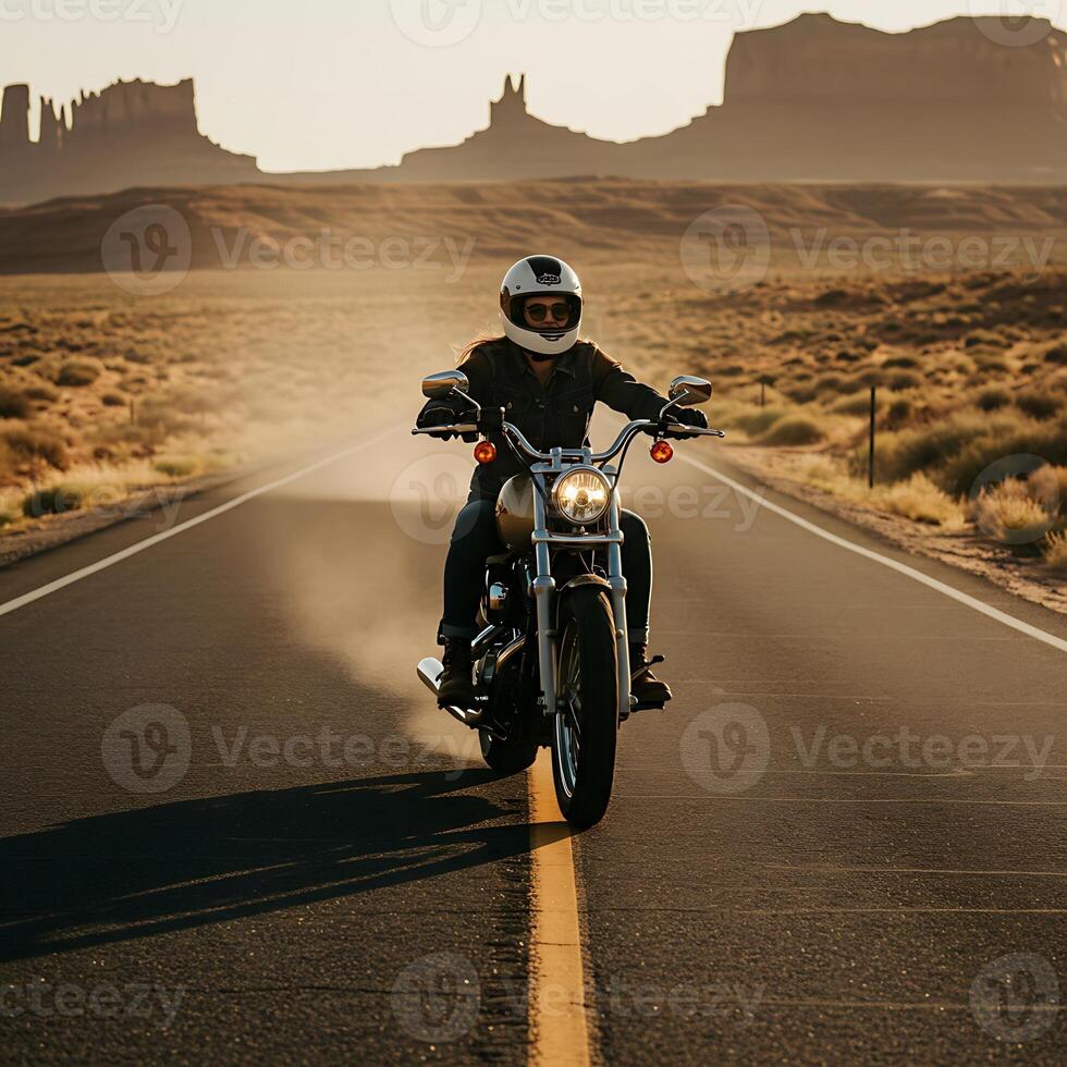 Woman Riding Motorcycle on Open Road Through Desert Landscape photo