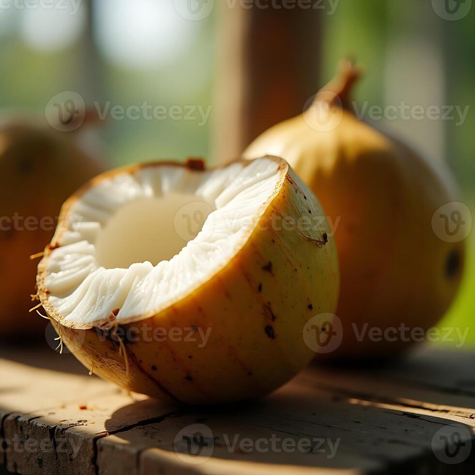 Cutting coconut close up on wooden table in the sun photo