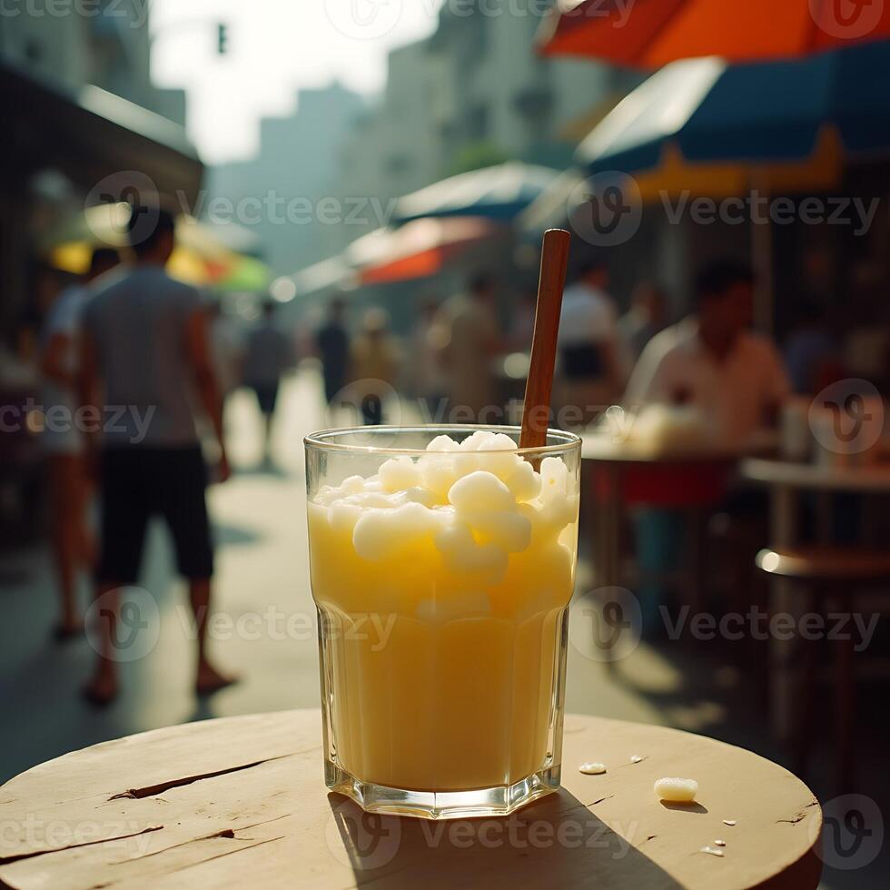 Refreshing Yellow Drink with Ice on Outdoor Table in City Street photo