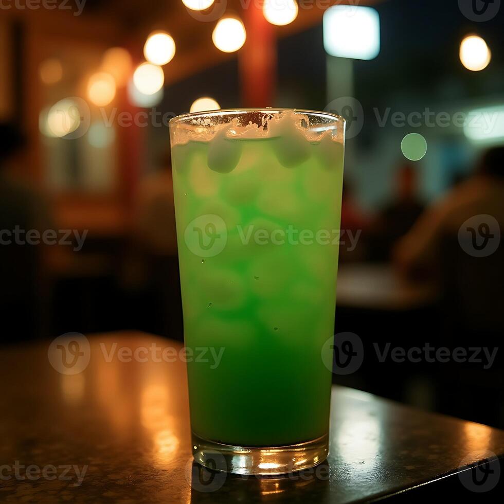 Refreshing Green Drink with Ice Cubes on Table at Night photo