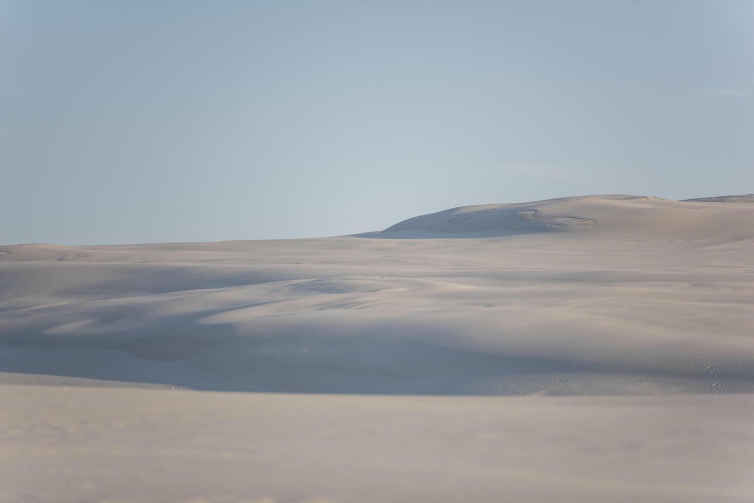A person standing on top of a hill in the middle of a desert photo