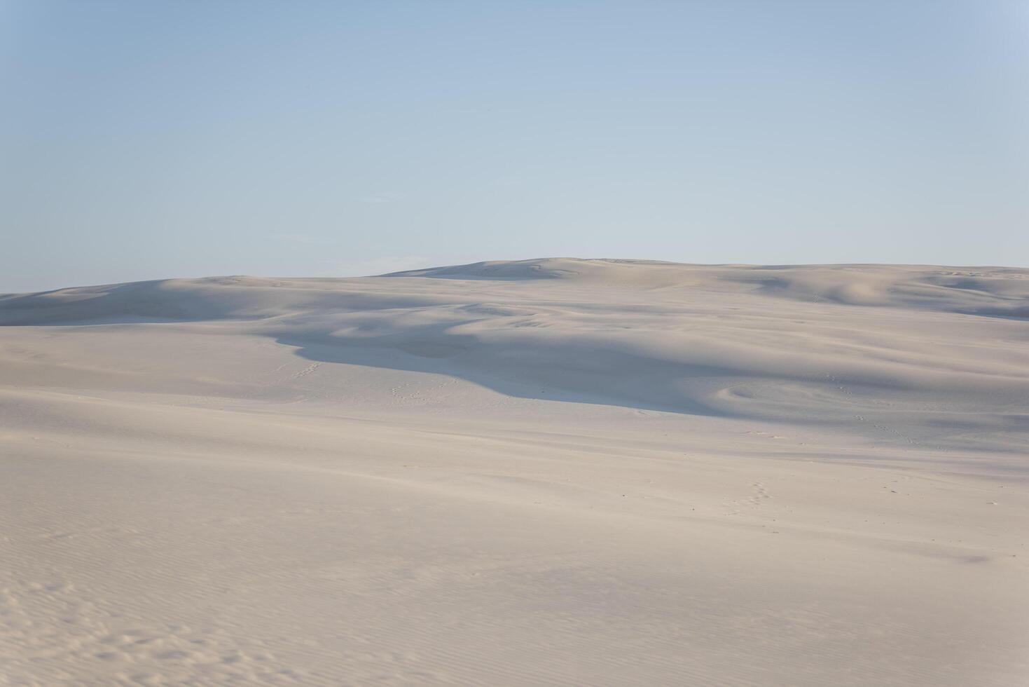 A person riding a skateboard on a sandy beach photo