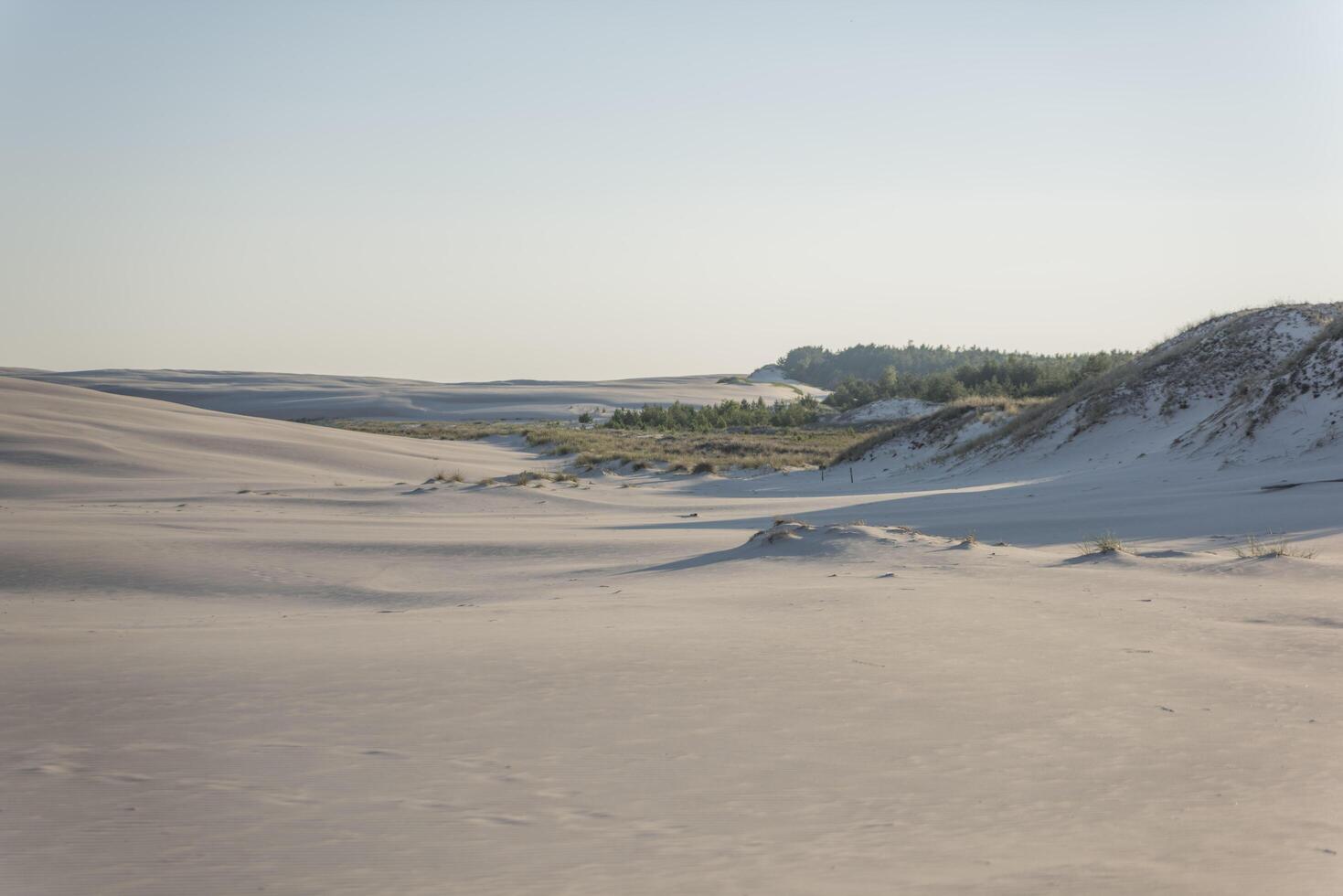 A person is walking on a sandy beach photo